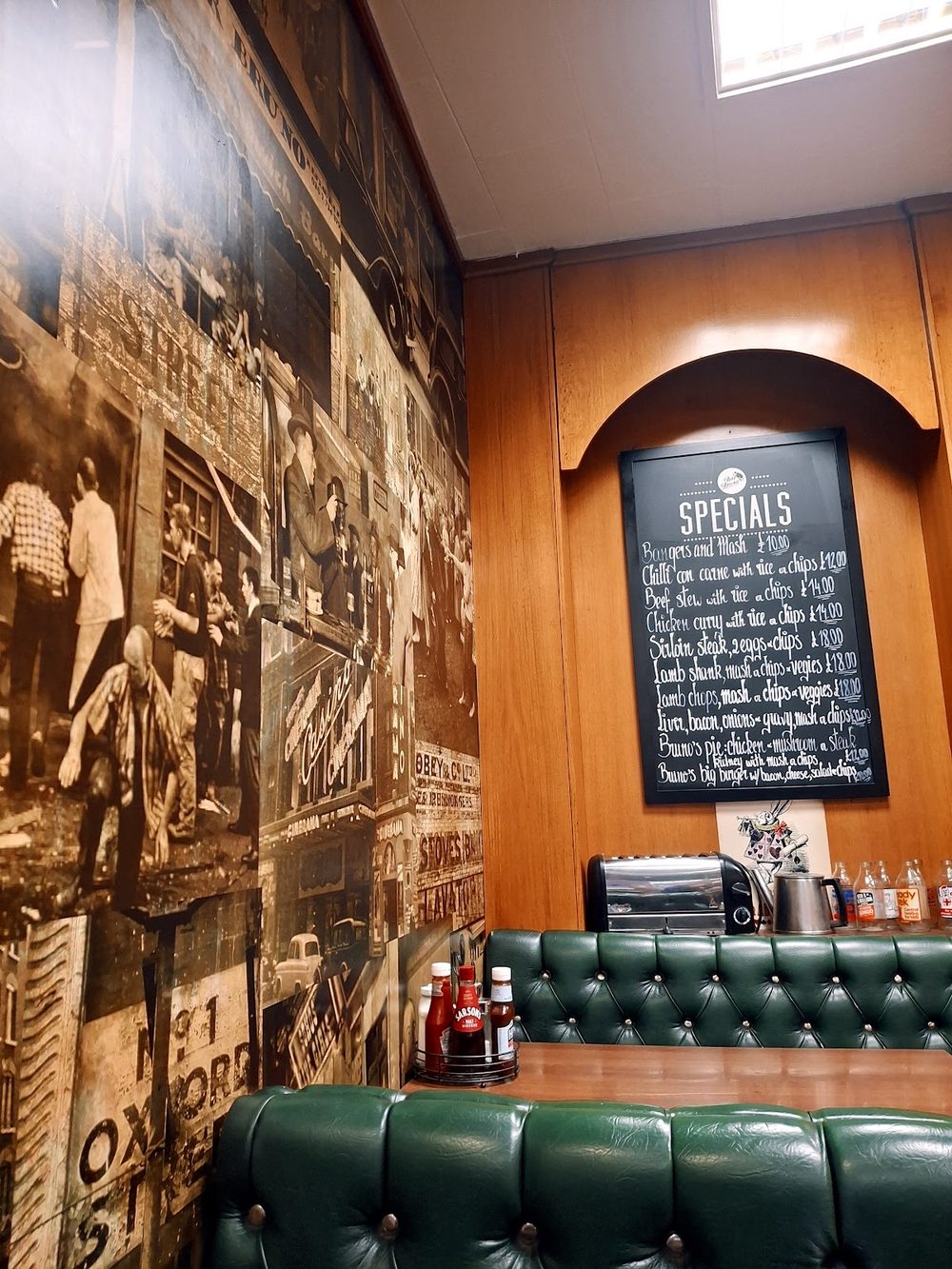 Inside Bar Bruno: green leather banquettes, wood panelling and a sepia photo-mural along the wall
