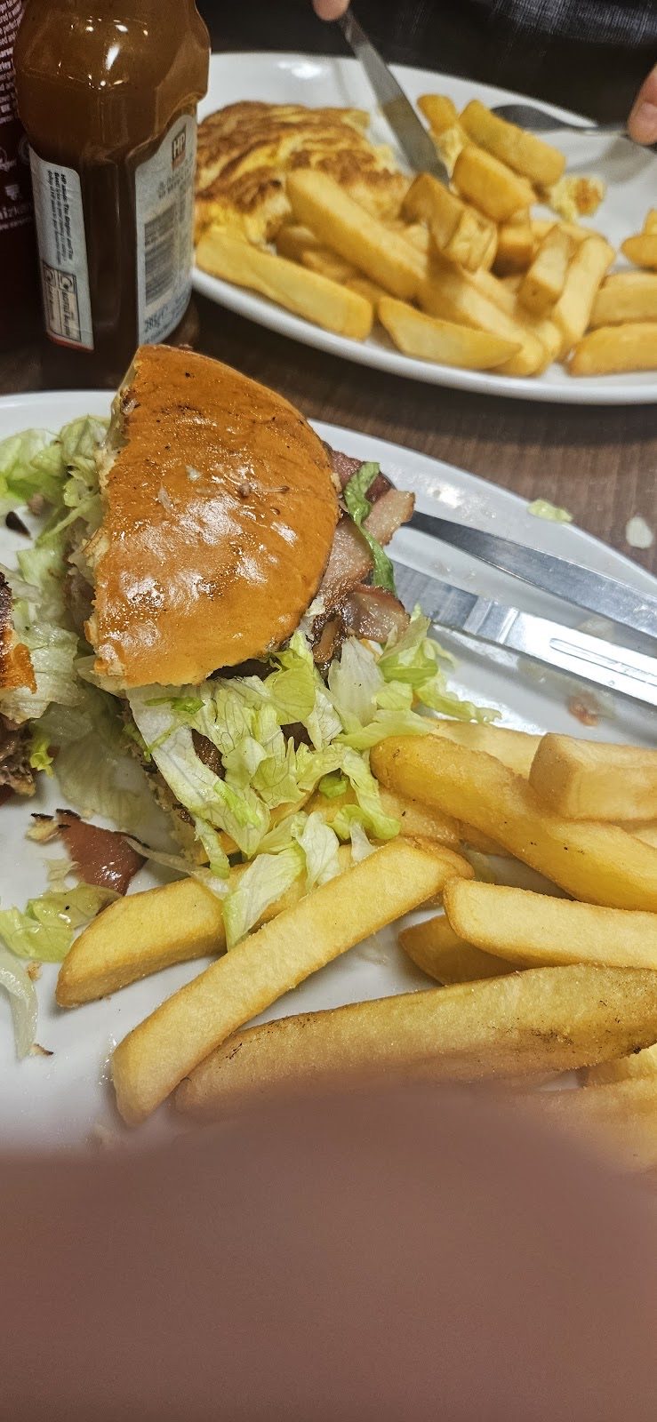 Burger in a glazed bun with lettuce and chips